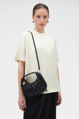 Profile view of model wearing the Oroton Clara Satin Mini Bag in Black and Satin fabric material for Women .