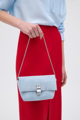 Profile view of model wearing the Oroton Etta Suede Mini Clutch in Blue Bird and Premium suede leather for Women .