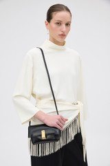 Profile view of model wearing the Oroton Etta Crackle Mini Clutch in Black and Soft crackle leather for Women .