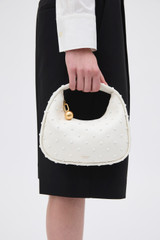 Profile view of model wearing the Oroton Clara Studded Mini Bag in Warm White and Smooth cow leather for Women .