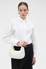 Profile view of model wearing the Oroton Clara Studded Mini Bag in Warm White and Smooth cow leather for Women .
