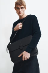 Profile view of model wearing the Oroton Nicholas Smooth Satchel Messenger in Black and Soft nappa cow leather for Men .