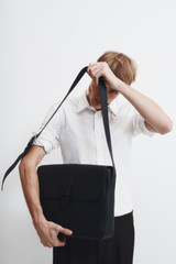 Profile view of model wearing the Oroton Nicholas Smooth Satchel Messenger in Black and Soft nappa cow leather for Men .