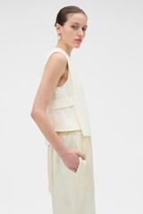 Profile view of model wearing the Oroton Fringe Detail Top in Soft Cream and 96% viscose and 4% spandex blend fabric for Women .