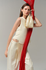 Profile view of model wearing the Oroton Fringe Detail Top in Soft Cream and 96% viscose and 4% spandex blend fabric for Women .