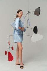 Profile view of model wearing the Oroton Double Satin Mini Dress in Cloud Blue and 100% viscose fabric for Women .