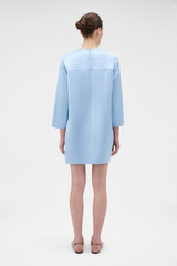 Profile view of model wearing the Oroton Double Satin Mini Dress in Cloud Blue and 100% viscose fabric for Women .