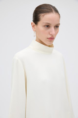 Profile view of model wearing the Oroton Scarf Detail Top in Soft Cream and 96% viscose and 4% spandex blend fabric for Women .