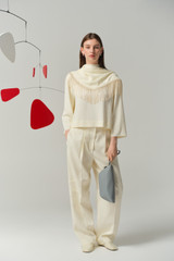 Profile view of model wearing the Oroton Scarf Detail Top in Soft Cream and 96% viscose and 4% spandex blend fabric for Women .