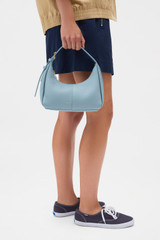 Profile view of model wearing the Oroton Dorit Mini Hobo in Sky Blue and Premium pebble leather for Women .