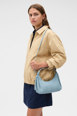 Profile view of model wearing the Oroton Dorit Mini Hobo in Sky Blue and Premium pebble leather for Women .