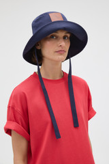 Profile view of model wearing the Oroton Nell Bucket Hat in North Sea and 100% cotton canvas fabric for Women .