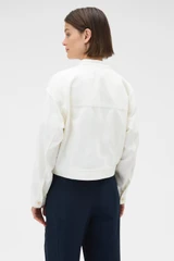 Profile view of model wearing the Oroton Curved Sleeve Jacket in Antique White and 100% cotton fabric for Women .
