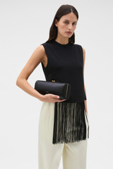 Profile view of model wearing the Oroton Penny Satin Clutch in Black and Satin fabric for Women .
