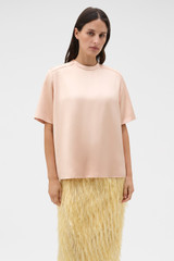 Profile view of model wearing the Oroton Double Satin Tee in Peach and 100% viscose fabric for Women .
