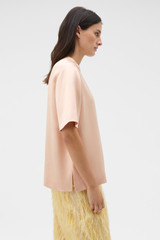 Profile view of model wearing the Oroton Double Satin Tee in Peach and 100% viscose fabric for Women .