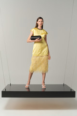 Profile view of model wearing the Oroton Feather Jacquard Sheath Dress in Butter and 100% polyester fabric for Women .