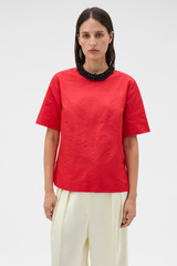 Profile view of model wearing the Oroton Beaded Collar Tee in Poppy and 100% polyester moiré taffeta fabric for Women .