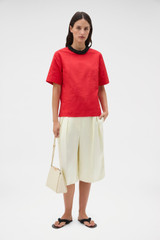 Profile view of model wearing the Oroton Beaded Collar Tee in Poppy and 100% polyester moiré taffeta fabric for Women .