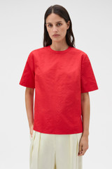 Profile view of model wearing the Oroton Beaded Collar Tee in Poppy and 100% polyester moiré taffeta fabric for Women .