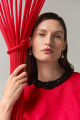 Profile view of model wearing the Oroton Beaded Collar Tee in Poppy and 100% polyester moiré taffeta fabric for Women .