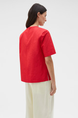 Profile view of model wearing the Oroton Beaded Collar Tee in Poppy and 100% polyester moiré taffeta fabric for Women .