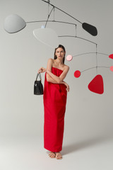 Profile view of model wearing the Oroton Tuck Detail Gown in Poppy and 85% polyester and 15% silk Mikado fabric for Women .