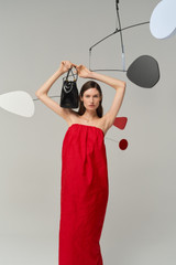 Profile view of model wearing the Oroton Tuck Detail Gown in Poppy and 85% polyester and 15% silk Mikado fabric for Women .