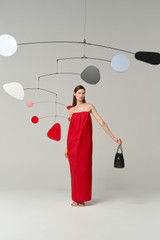 Profile view of model wearing the Oroton Tuck Detail Gown in Poppy and 85% polyester and 15% silk Mikado fabric for Women .