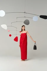 Profile view of model wearing the Oroton Tuck Detail Gown in Poppy and 85% polyester and 15% silk Mikado fabric for Women .