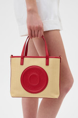 Profile view of model wearing the Oroton Polly Straw Small Tote in Natural/Dark Ruby and Woven straw material for Women .