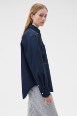 Profile view of model wearing the Oroton Oxford Shirt in North Sea and 100% cotton fabric for Women .