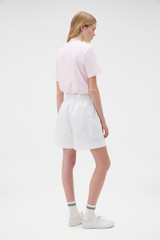 Profile view of model wearing the Oroton Flat Front Carpenter Short in Antique White and 100% cotton fabric for Women .