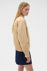 Profile view of model wearing the Oroton Drill Bomber in Praline and 100% cotton fabric for Women .