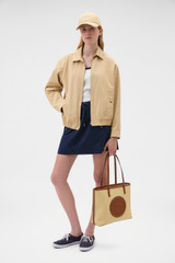 Profile view of model wearing the Oroton Drill Bomber in Praline and 100% cotton fabric for Women .