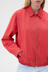 Profile view of model wearing the Oroton Drill Bomber in Robbin Red and 100% cotton fabric for Women .