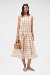 Profile view of model wearing the Oroton Sheer Check Drop Waist Dress in Butterscotch and 80% cotton and 20% lightweight silk blend fabric for Women .