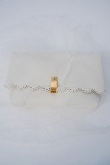 Profile view of model wearing the Oroton Etta Smooth Broidery Medium Clutch in Warm White and Smooth cow leather for Women .