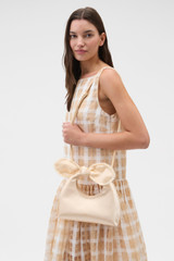 Profile view of model wearing the Oroton Myrtle Satin Mini Bag in Peach and Satin fabric material for Women .