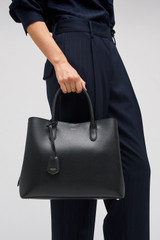 Profile view of model wearing the Oroton Muse Three Pocket Day Bag in Black and Premium saffiano and split calf leather for Women .