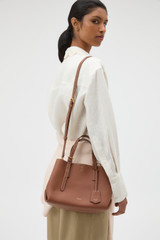 Profile view of model wearing the Oroton Margot Mini Day Bag in Whiskey and Pebble Leather for Women .