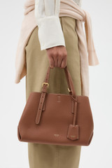 Profile view of model wearing the Oroton Margot Mini Day Bag in Whiskey and Pebble Leather for Women .
