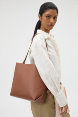 Profile view of model wearing the Oroton Margot Hobo in Whiskey and Pebble leather for Women .
