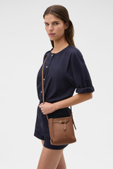 Profile view of model wearing the Oroton Margot Tiny Bucket Bag in Whiskey and Premium smooth leather for Women .