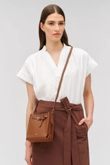 Profile view of model wearing the Oroton Margot Tiny Bucket Bag in Whiskey and Premium smooth leather for Women .