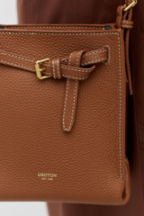 Profile view of model wearing the Oroton Margot Tiny Bucket Bag in Whiskey and Premium smooth leather for Women .