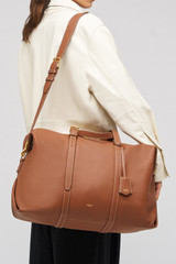 Profile view of model wearing the Oroton Margot Weekender in Whiskey and Pebble Leather for Women .