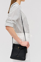 Profile view of model wearing the Oroton Margot Mini Bucket Bag in Black and Pebble leather for Women . IP:3