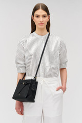 Profile view of model wearing the Oroton Margot Mini Bucket Bag in Black and Pebble leather for Women . IP:2