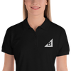 Women's B Mark polo t-shirt front view logo detail, on a small model.